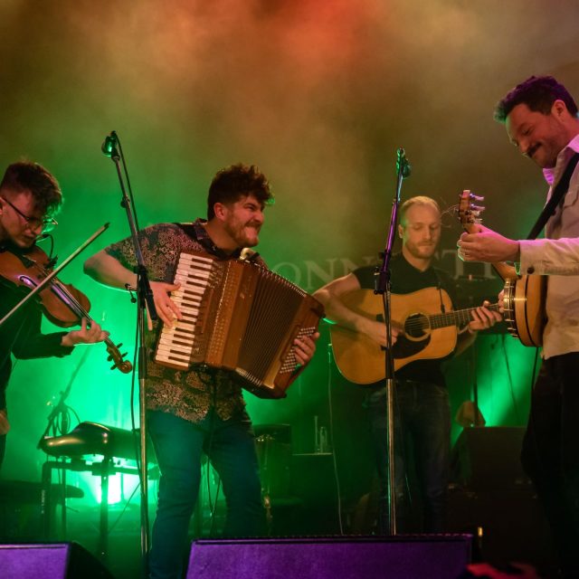 Four folk musicians on stage